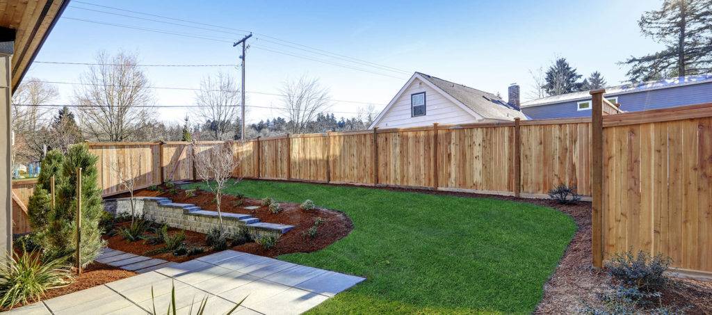 Sloped Backyard Surrounded By Wooden Fence Luxury New Constructi